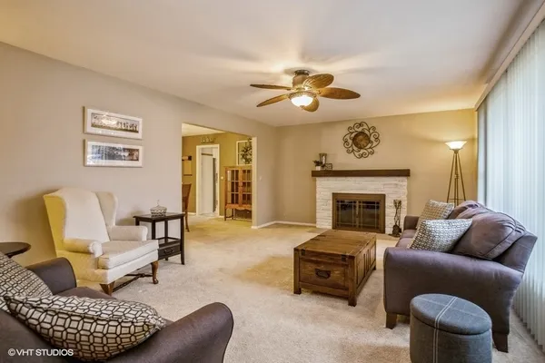 a living room with furniture a fireplace and a large window