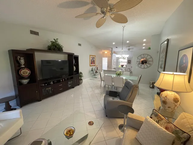 a living room with furniture kitchen view and a flat screen tv