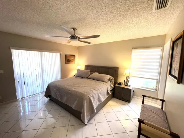 a bathroom with a granite countertop sink a toilet a mirror and shower