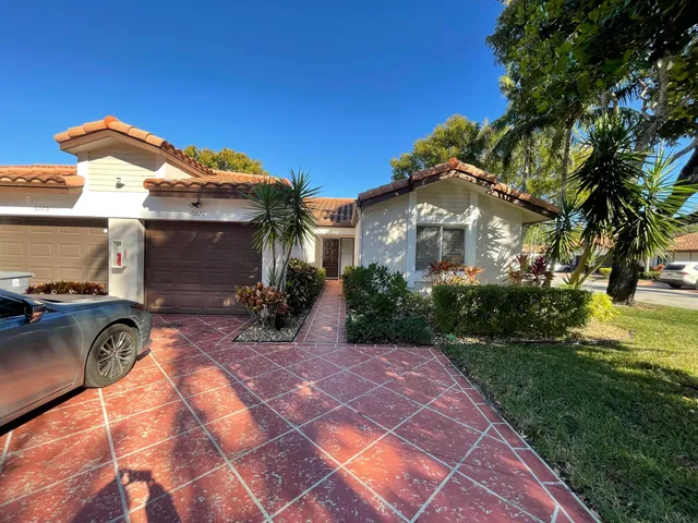 a front view of house with yard and trees around