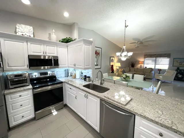 a kitchen with stainless steel appliances kitchen island granite countertop a sink and cabinets