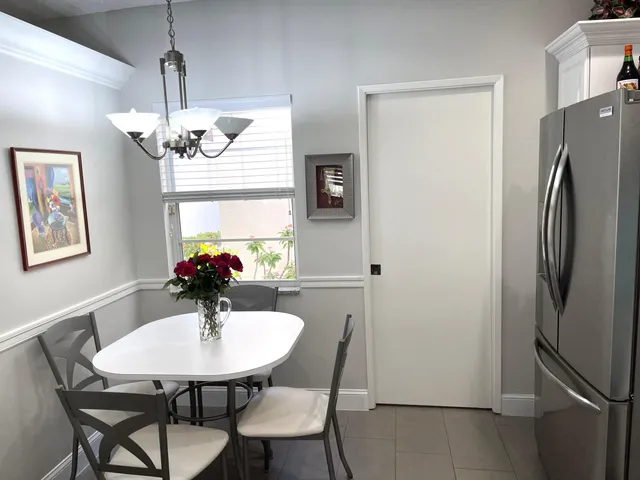 a living room with couch a dining table and a chandelier