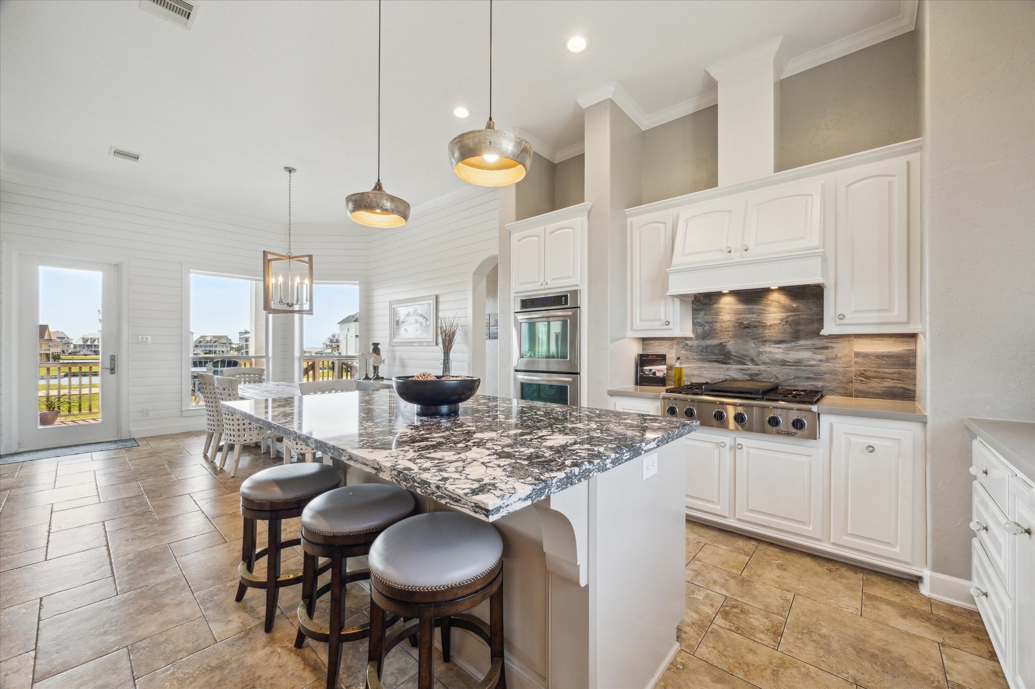7 Ramrod Hitchcock, TX 77563 - Photo 11 of 41 a kitchen with stainless steel appliances kitchen island granite countertop a stove a sink dishwasher a dining table and chairs with wooden floor