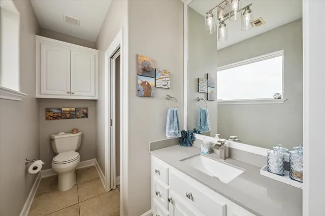 a bathroom with a granite countertop toilet a sink and a mirror