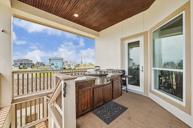 a open kitchen with stainless steel appliances granite countertop a stove a refrigerator a sink with wooden cabinets and glass door