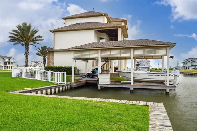 a front view of a house with a garden and lake view