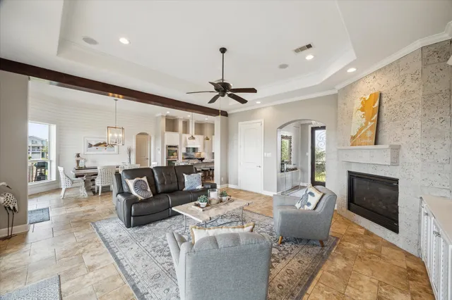 a living room with furniture a fireplace and a chandelier