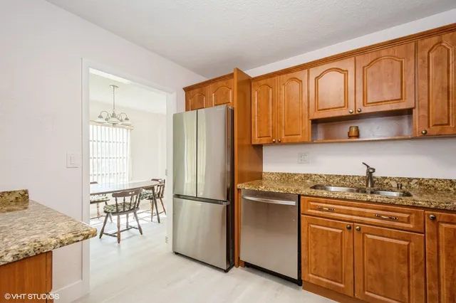 a kitchen with stainless steel appliances granite countertop a refrigerator sink and cabinets