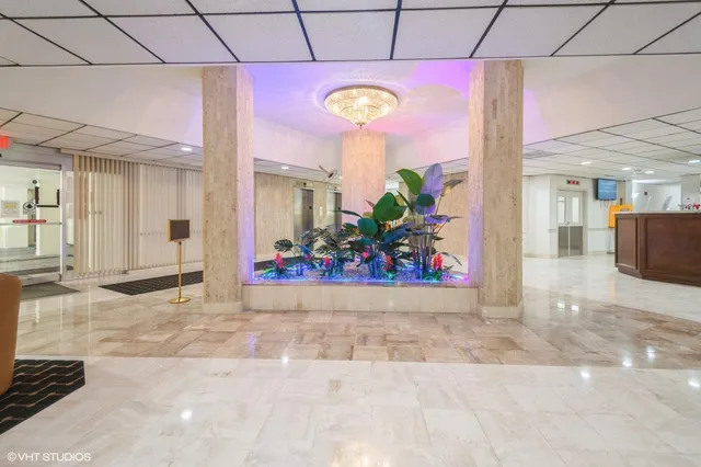 a view of a hallway with a dining table and chairs