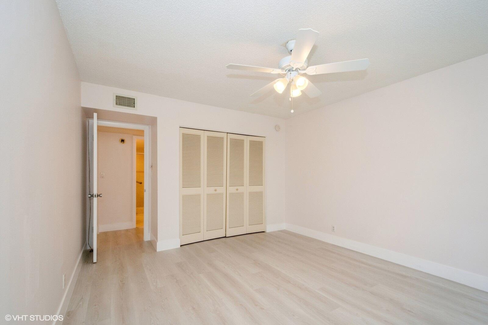 10777 West Sample Road, Unit 101 Coral Springs, FL 33065 - Photo 23 of 36 an empty room with closet and a ceiling fan
