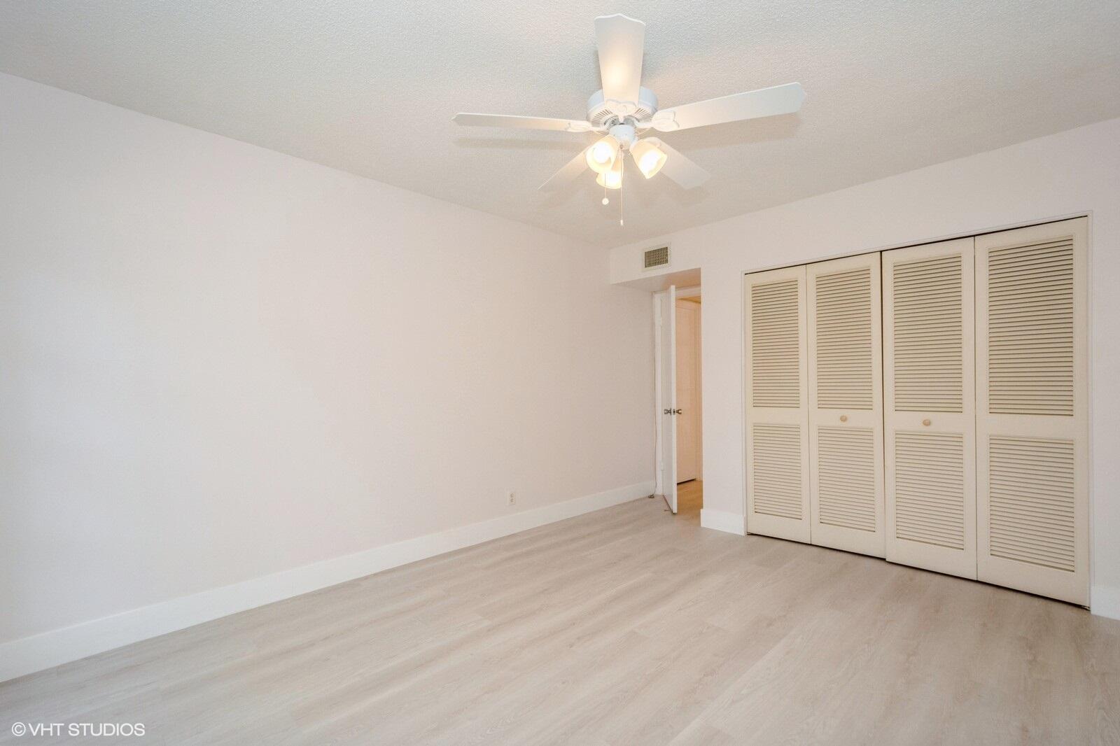 10777 West Sample Road, Unit 101 Coral Springs, FL 33065 - Photo 24 of 36 an empty room with a ceiling fan and window