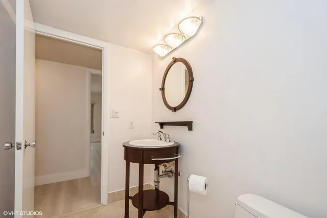 a bathroom with a toilet a sink and a mirror