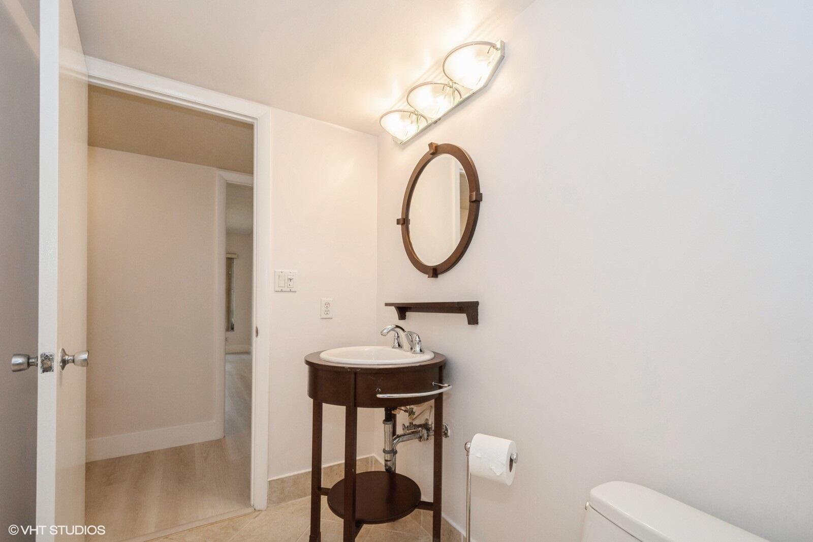 10777 West Sample Road, Unit 101 Coral Springs, FL 33065 - Photo 25 of 36 a bathroom with a toilet a sink and a mirror