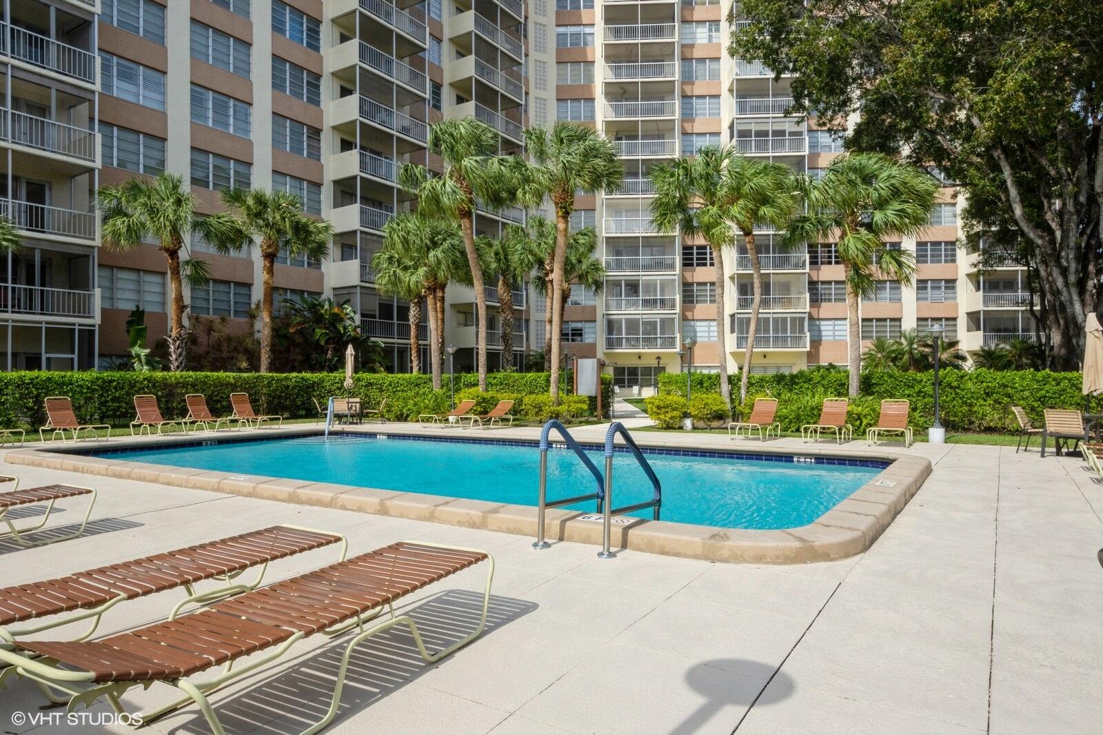 10777 West Sample Road, Unit 101 Coral Springs, FL 33065 - Photo 31 of 36 a view of a swimming pool with a lounge chair