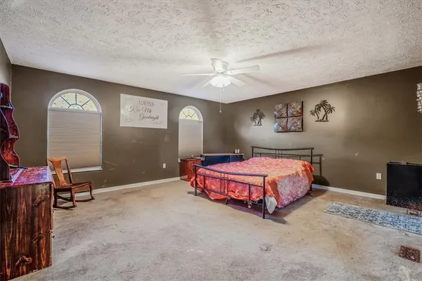 a spacious bedroom with a bed and a lamp
