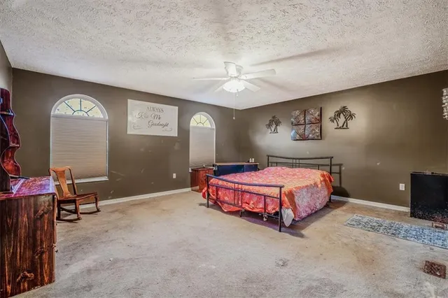 a spacious bedroom with a bed and a lamp