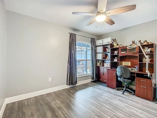 a view of a workspace with furniture and a ceiling fan