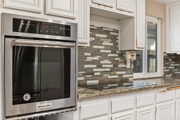 a kitchen with granite countertop a stove and a microwave