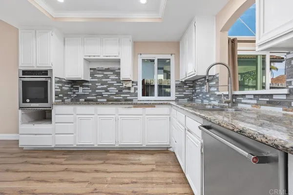 a kitchen with white cabinets and sink