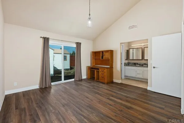 a view of a kitchen with refrigerator and wooden floor