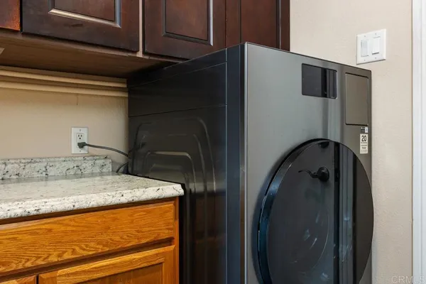 a bathroom with a granite countertop sink and washing machine
