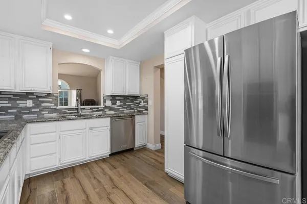 a kitchen with stainless steel appliances granite countertop a refrigerator and a stove top oven