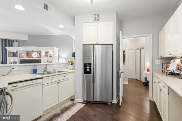 a kitchen with white cabinets and refrigerator