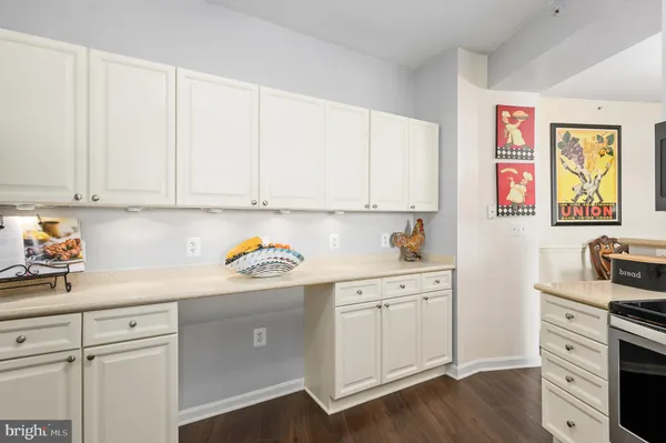 a kitchen with stainless steel appliances white cabinets and wooden floors