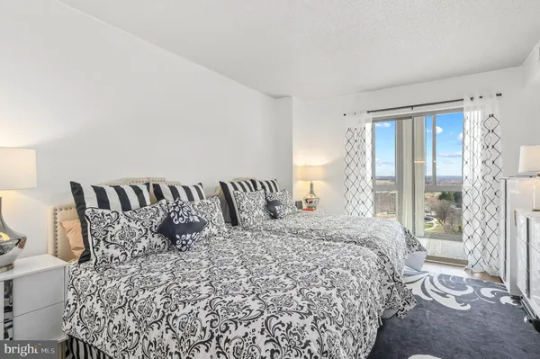 a large bed sitting in a bedroom next to a window
