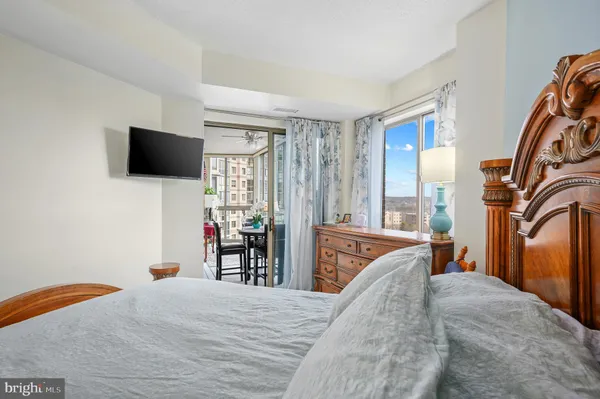 a bedroom with a bed and a flat tv screen on the dresser