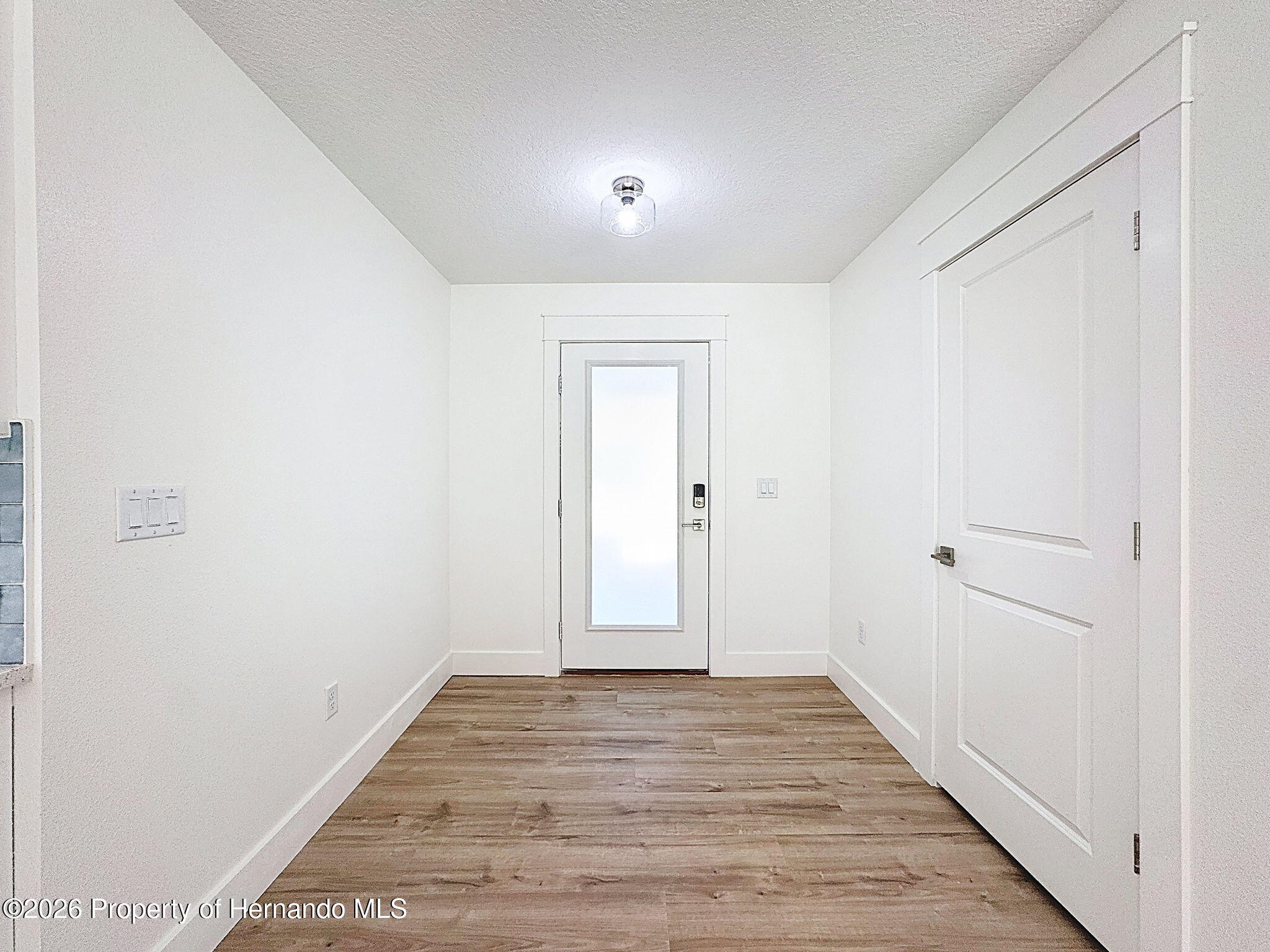 8988 Waterbird Way Weeki Wachee, FL 34613 - Photo 6 of 42 a view of a hallway with wooden floor