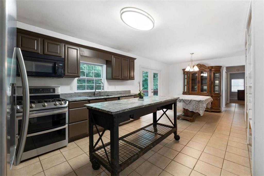 159 Moores Ferry Road Southwest Plainville, GA 30733 - Photo 21 of 43 a kitchen with stainless steel appliances granite countertop a stove refrigerator and cabinets