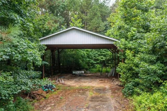 a view of a small house with a yard plants and large tree