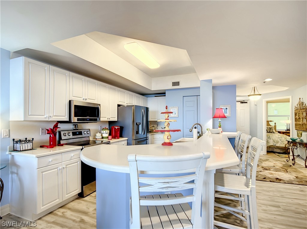 2797 First Street, Unit 1502 Fort Myers, FL 33916 - Photo 6 of 49 a view of a kitchen with kitchen island a sink stainless steel appliances and cabinets