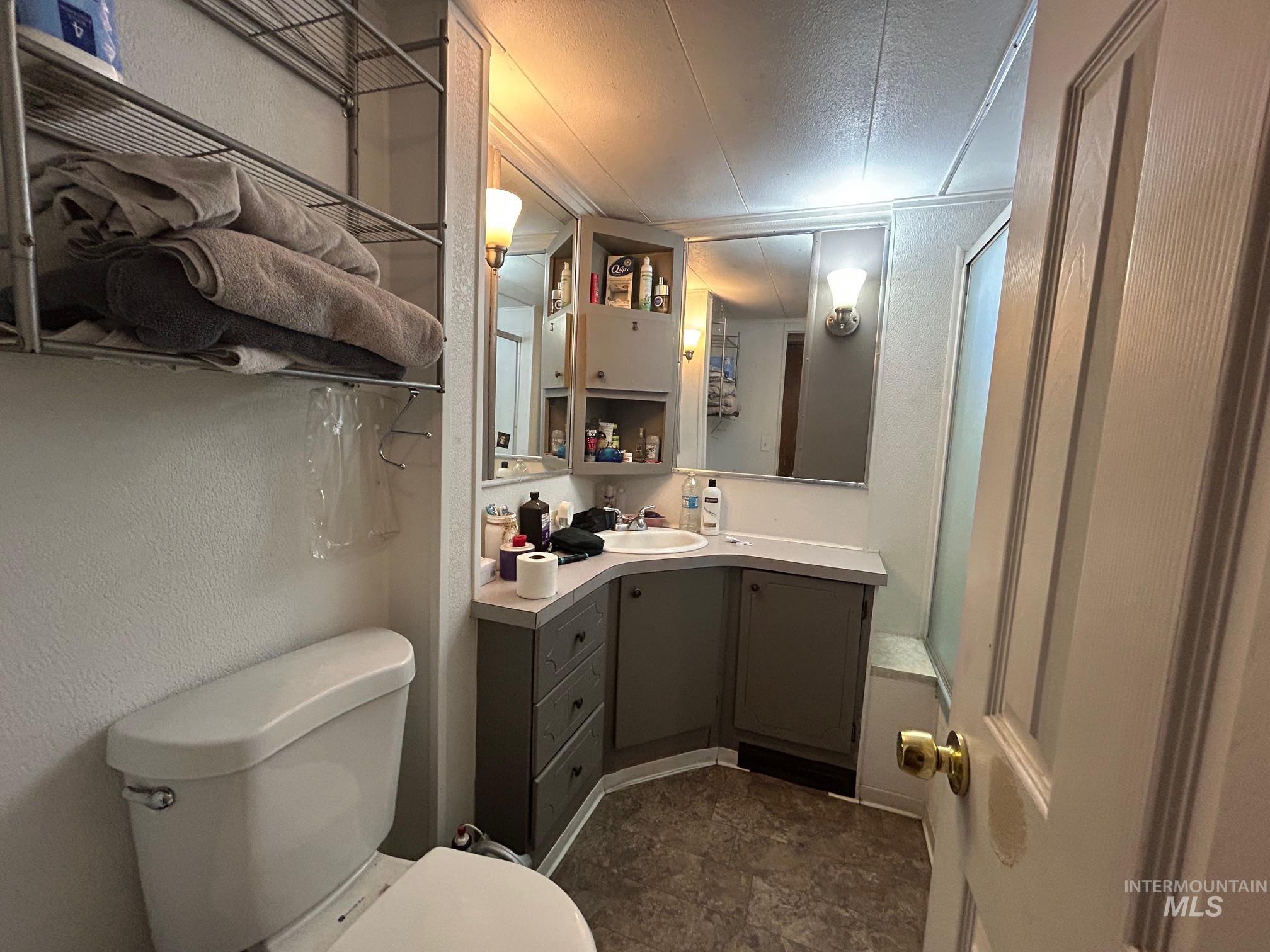 1383 Fair Street, Unit 7 Clarkston, WA 99403 - Photo 12 of 15 Full bath featuring vanity, a textured wall, a textured ceiling, and stone finish floors