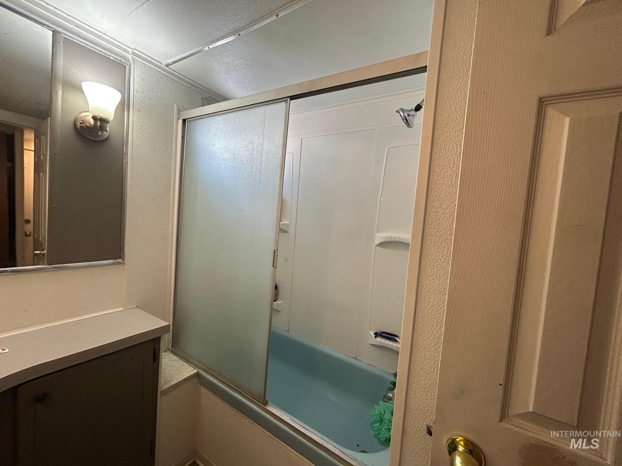 1383 Fair Street, Unit 7 Clarkston, WA 99403 - Photo 13 of 15 Bathroom with combined bath / shower with glass door and a textured wall