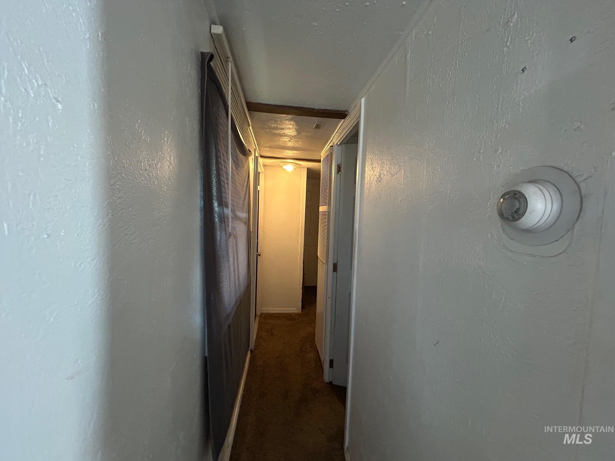 1383 Fair Street, Unit 7 Clarkston, WA 99403 - Photo 8 of 15 Hallway featuring dark colored carpet and a textured wall