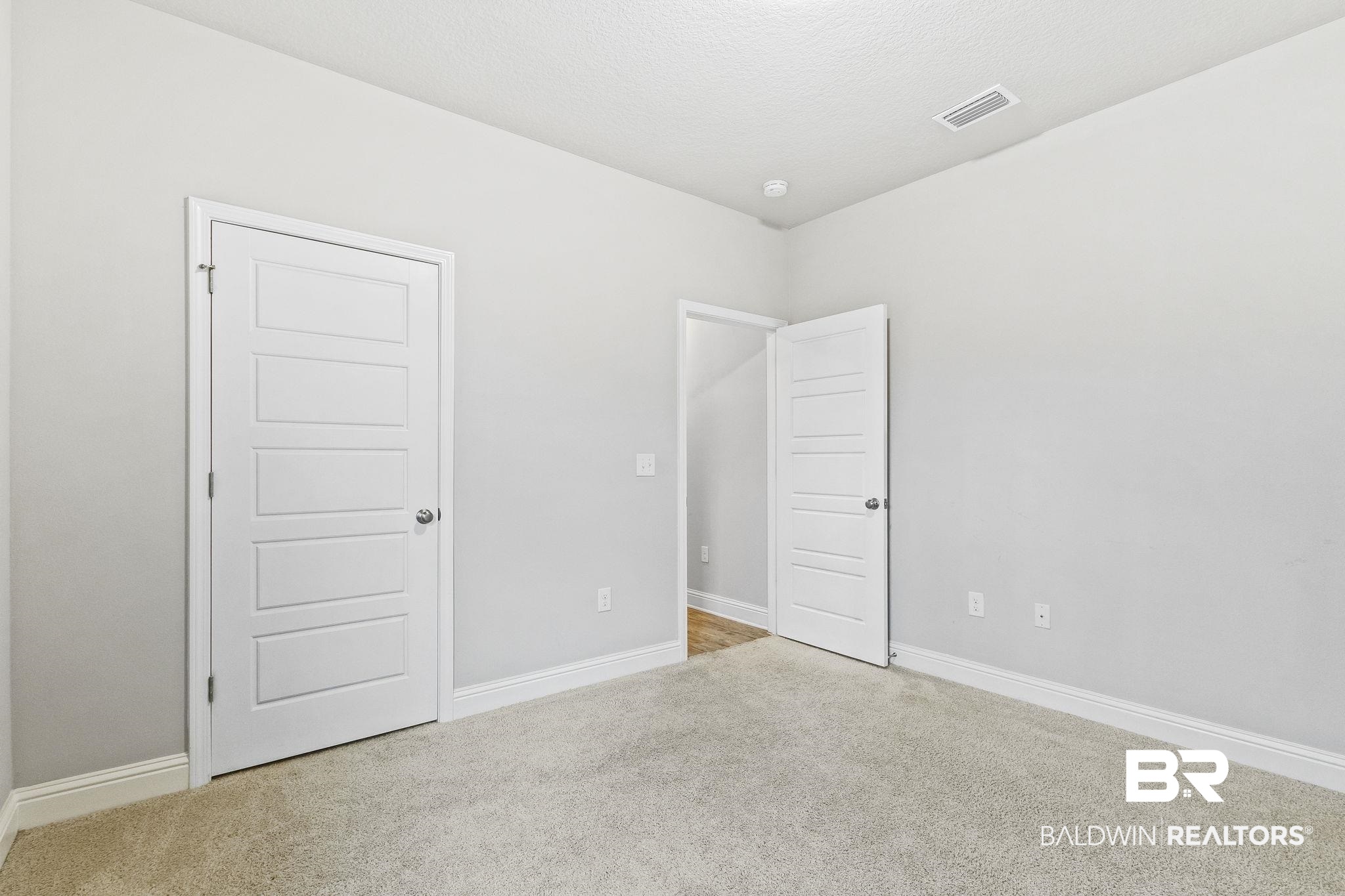 31643 Kestrel Loop Daphne, AL 36527 - Photo 33 of 59 Unfurnished bedroom featuring light colored carpet and a textured ceiling