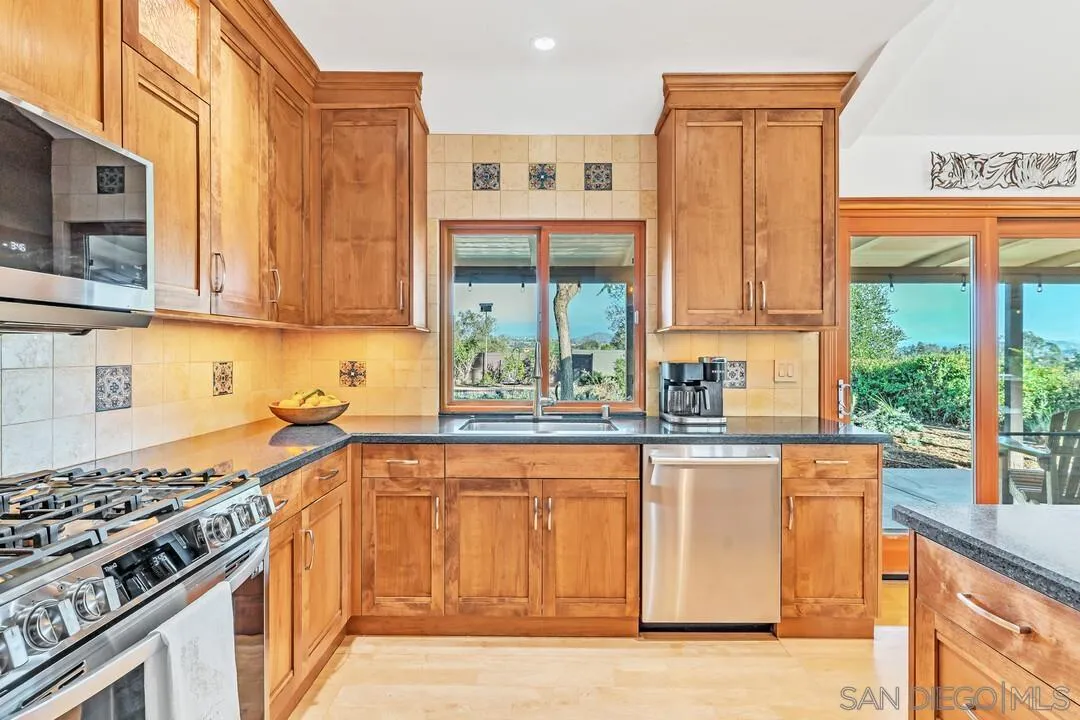 290 North Old Hill Road Fallbrook, CA 92028 - Photo 10 of 47 a kitchen with stainless steel appliances granite countertop a stove and a microwave
