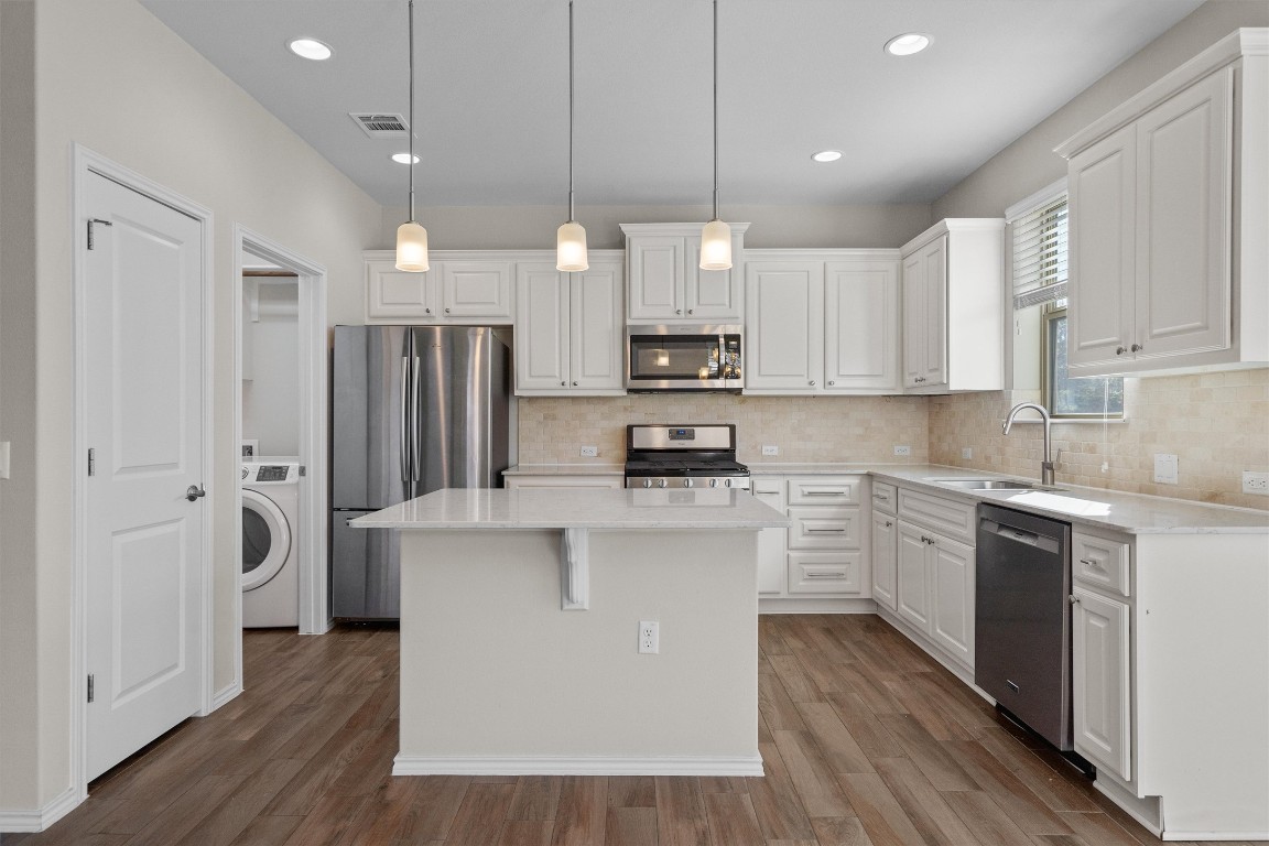 9416 Hunter Lane Austin, TX 78748 - Photo 10 of 35 a kitchen with stainless steel appliances a refrigerator a stove a sink dishwasher and a oven with white cabinets