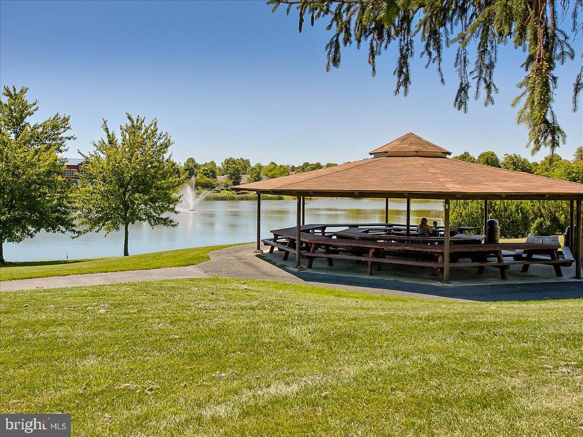 2141 Wainwright Court, Unit BA Frederick, MD 21702 - Photo 31 of 42 Serene lakeside gazebo in lush greenery.