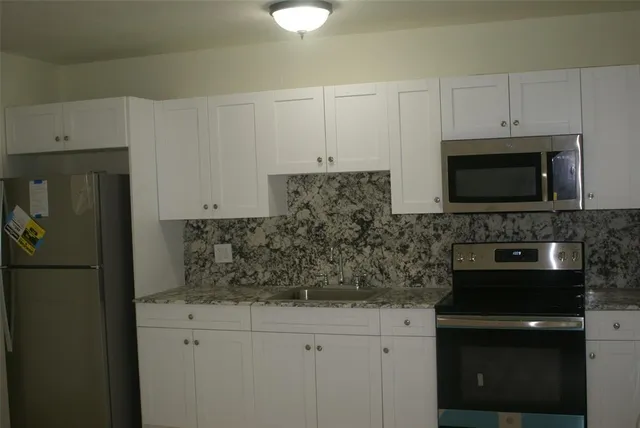 a kitchen with appliances a sink and cabinets