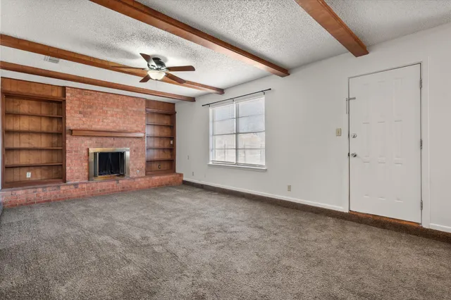 an empty room with fireplace and fan