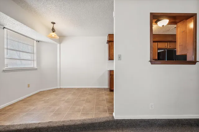 an empty room with windows and cabinet