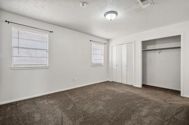 an empty room with windows and closet