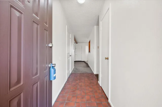 a view of a hallway with wooden floor and a shower