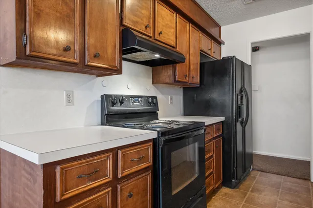 a kitchen with stainless steel appliances granite countertop a stove and a refrigerator