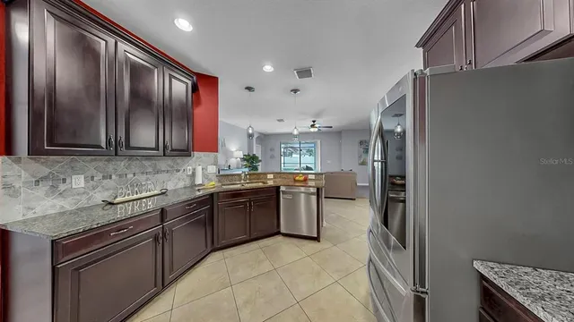 a kitchen with stainless steel appliances granite countertop a refrigerator and a stove top oven