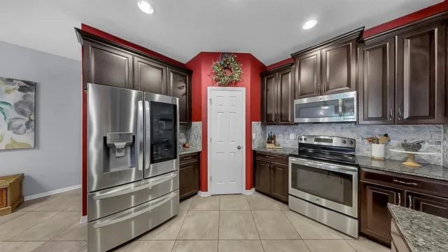 a kitchen with stainless steel appliances granite countertop a refrigerator and a sink