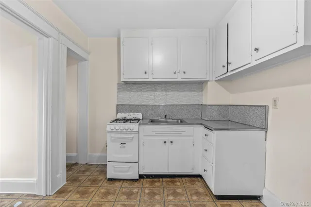 a kitchen with granite countertop white cabinets and appliances